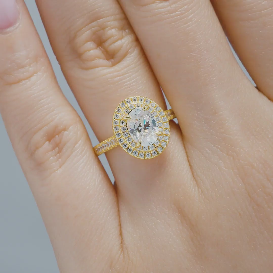 18k gold plated 925 sterling silver 1.5 carat oval cut double halo engagement ring being modeled by a model with neutral nails