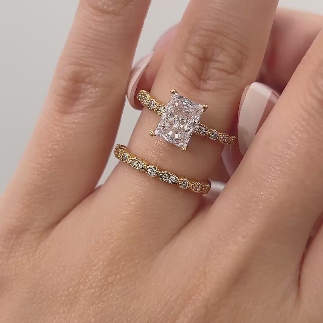 video of gold 1.5 carat radiant cut vintage style wedding ring set on model with french tip nails