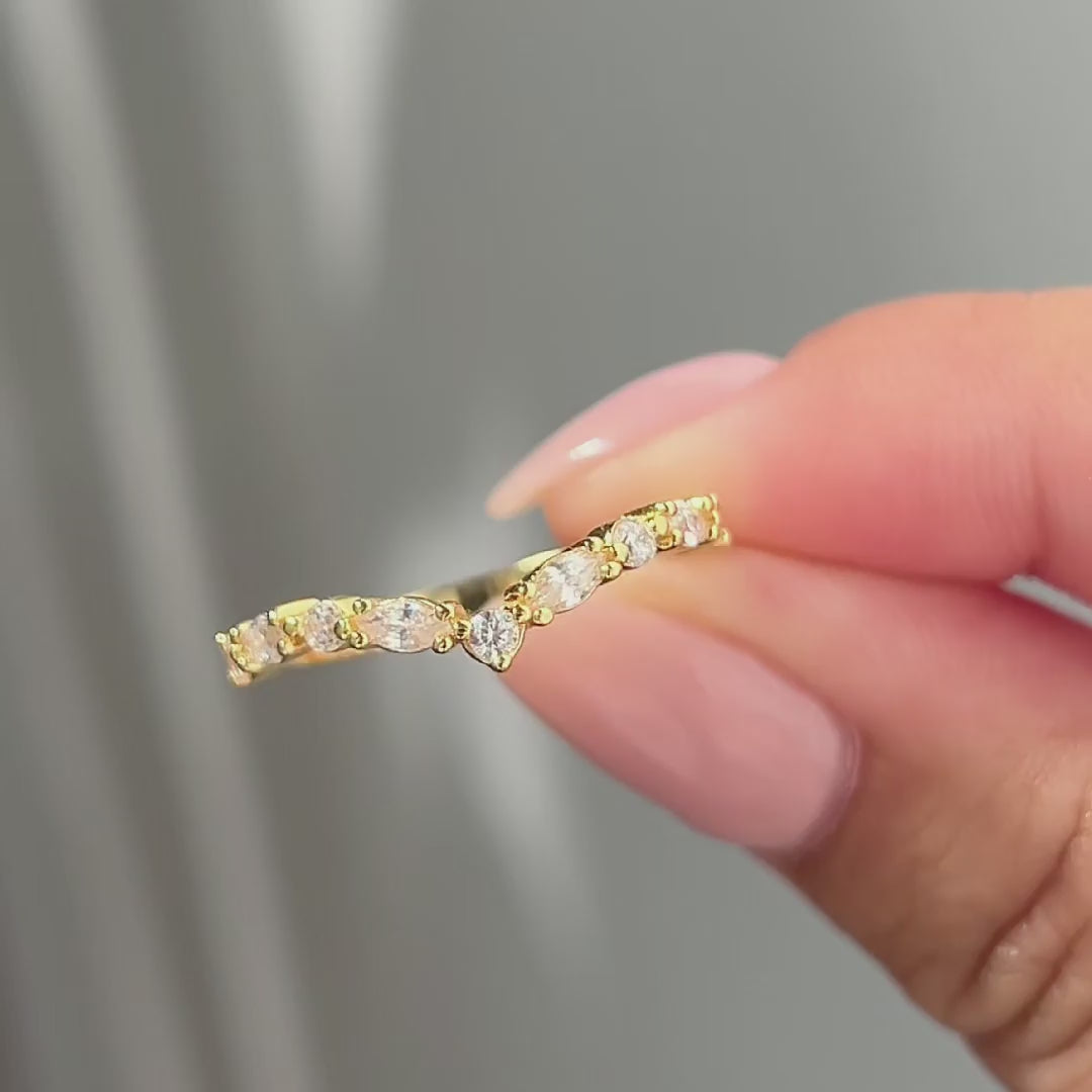 video of gold vintage chevron half eternity wedding band held by model with light pink nails