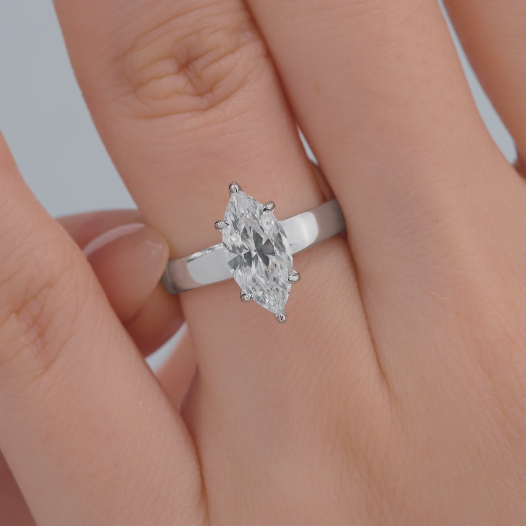 video of a thick, silver 2 carat marquise cut solitaire engagement ring on model