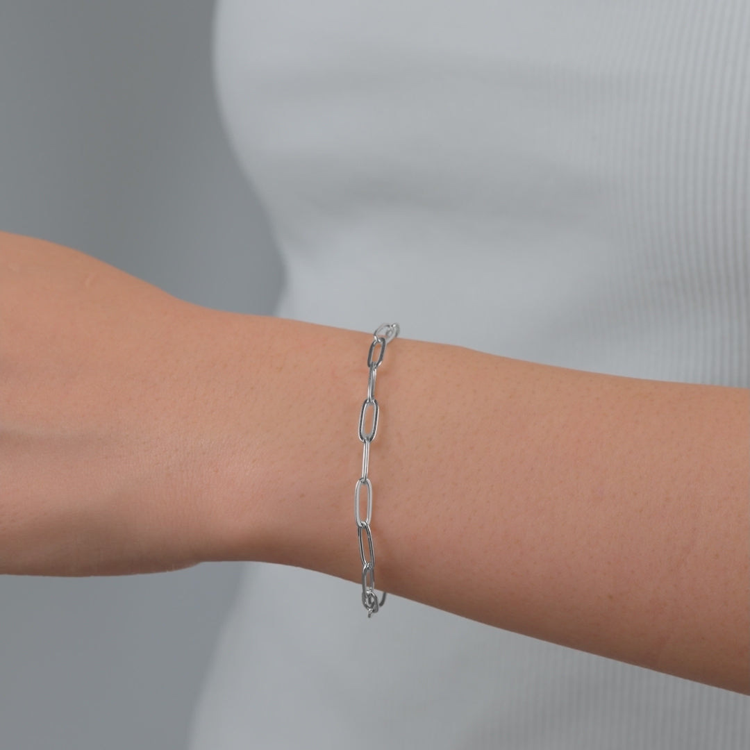 video of a silver paperclip style chain bracelet on a model 