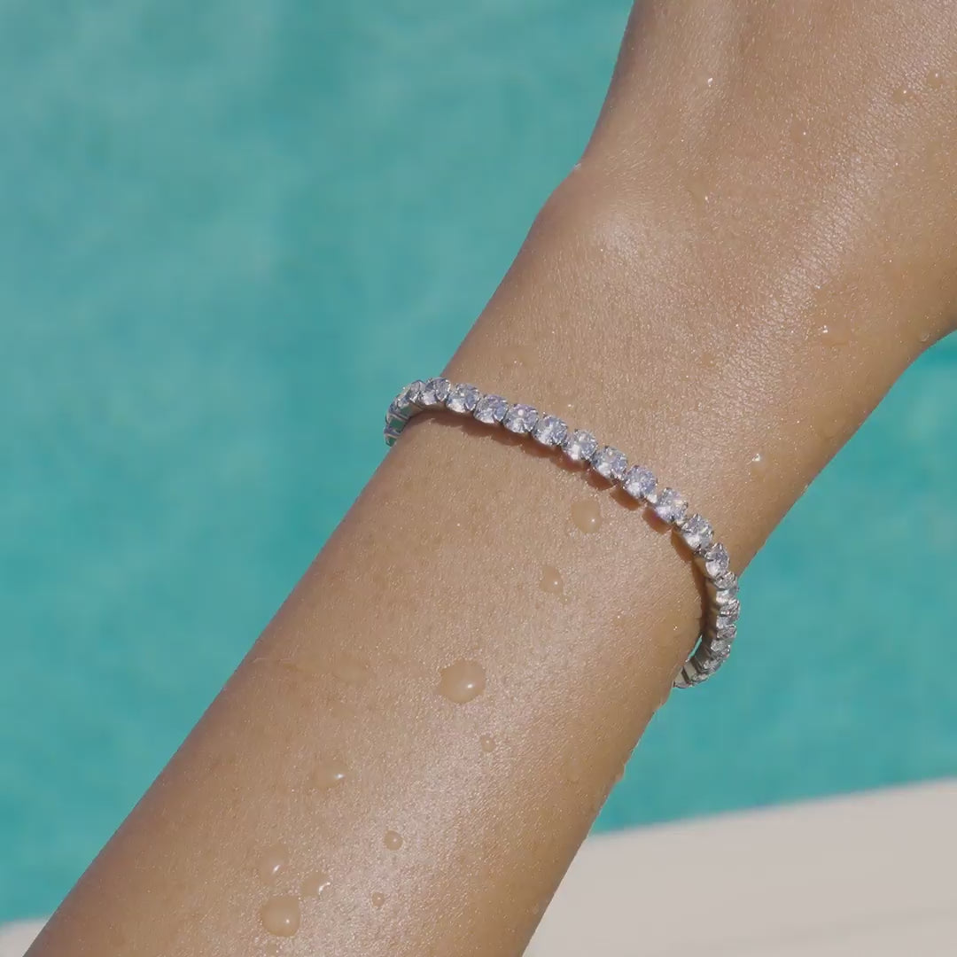 video of a stunning, waterproof, silver stainless steel tennis bracelet on a model by the pool