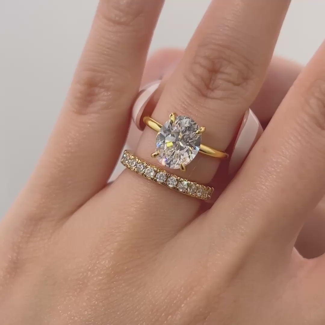 video of classic gold 3 carat oval cut wedding ring set on model with french tip nails