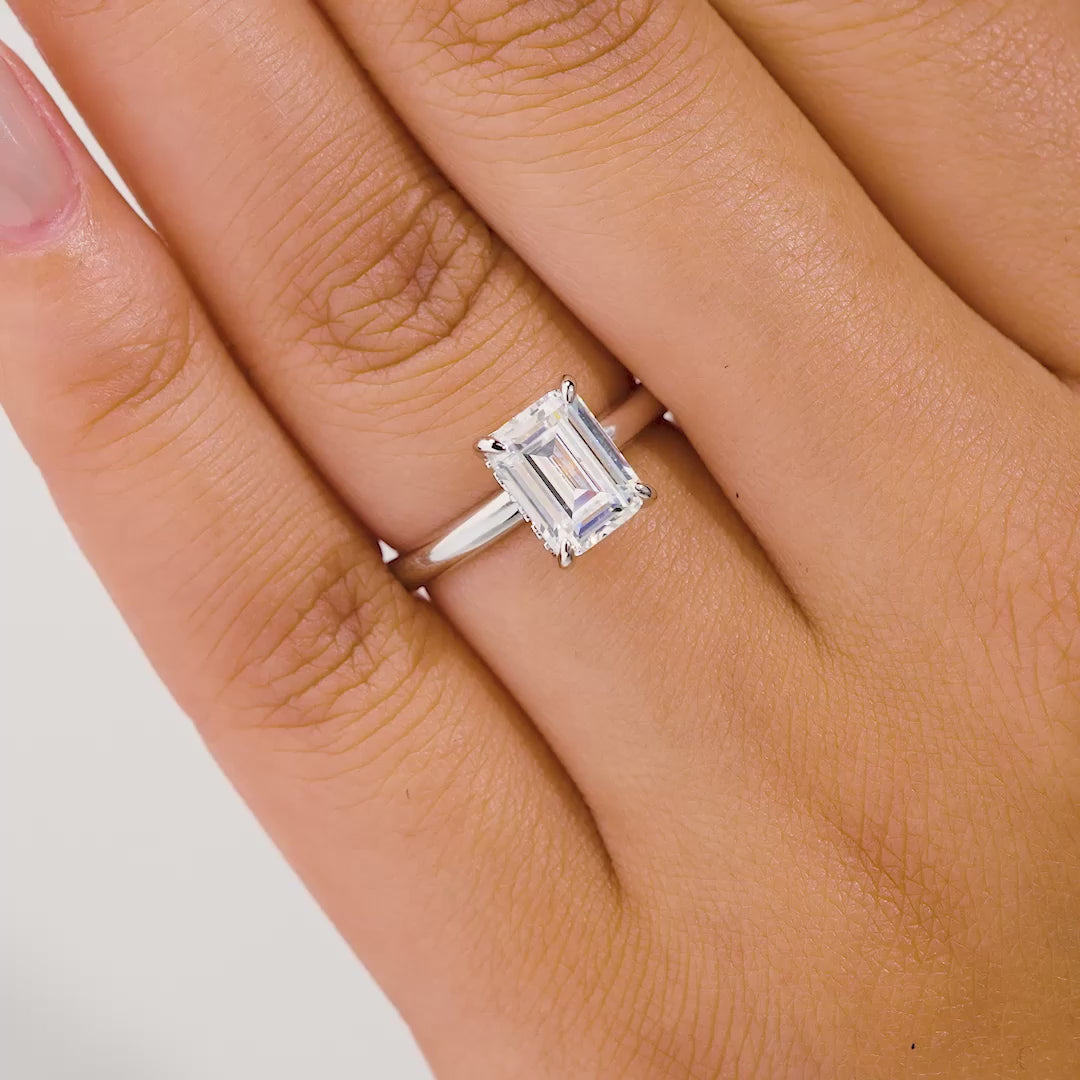 video of silver 1.5 carat emerald cut solitaire engagement ring on model