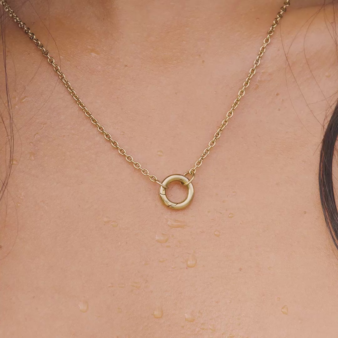 video of a 14k gold PVD plated stainless steel charm necklace worn by a model at the pool