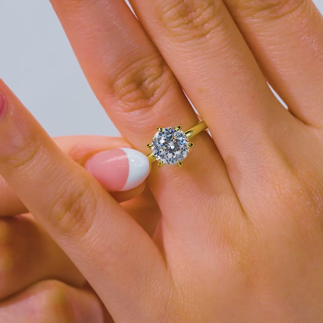 Video of a gold 2 carat 6 prong solitaire engagement ring on model with french tip nails 