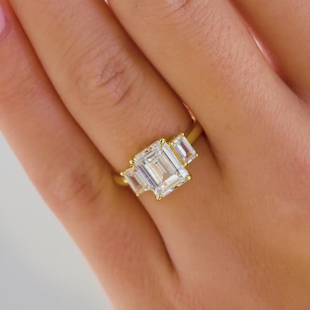 video of emerald cut trinity engagement ring on female model