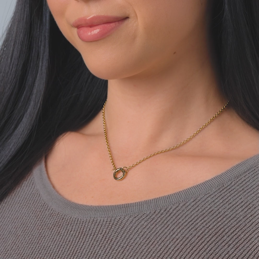 video of a dainty gold stainless steel cable chain charm necklace on a female model
