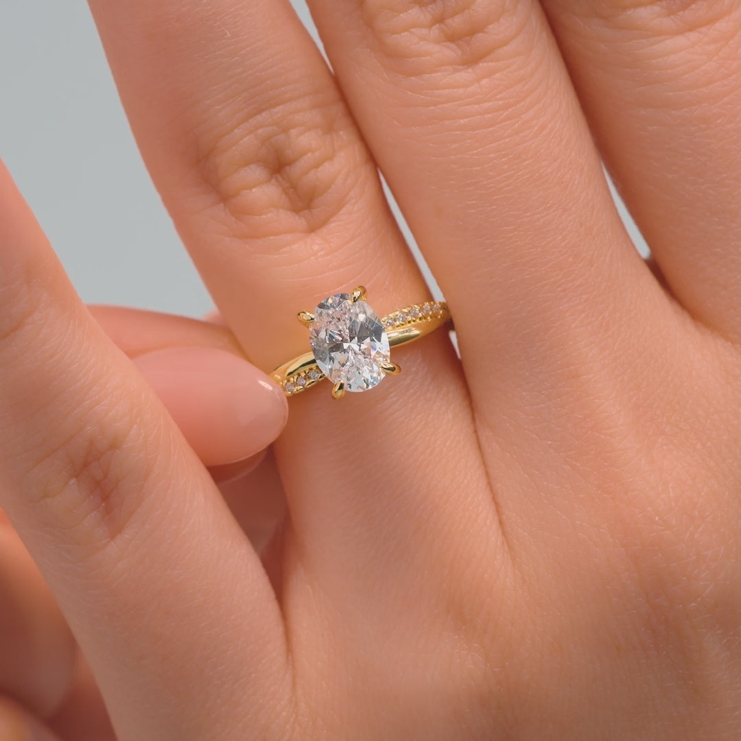 video of a gold 1.5 carat oval cut vintage style engagement ring with a twisting band detail on a model