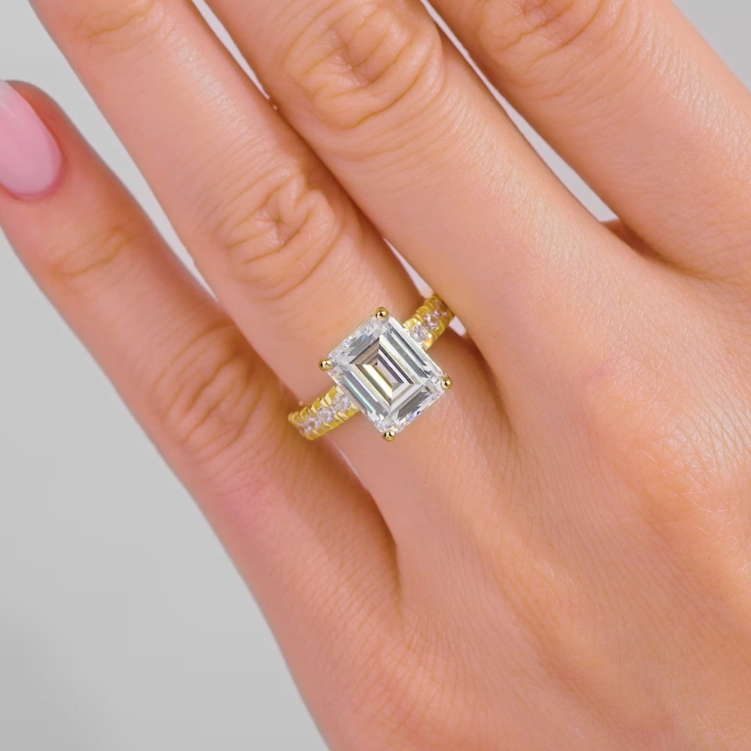 video of a stunning and bold emerald cut half eternity engagement ring on a model with light pink nails