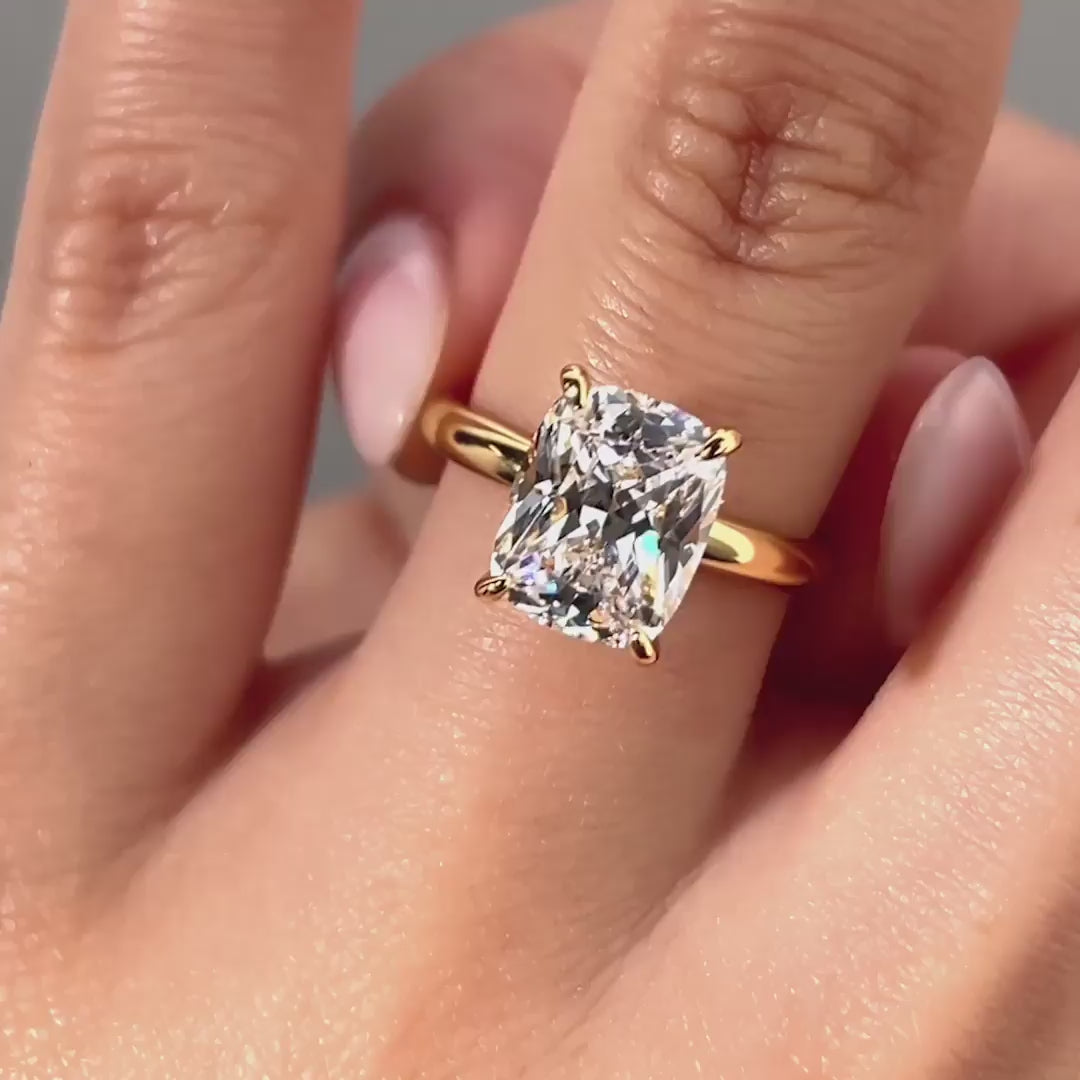 video of gold 4 carat elongated cushion cut solitaire with a hidden halo on model