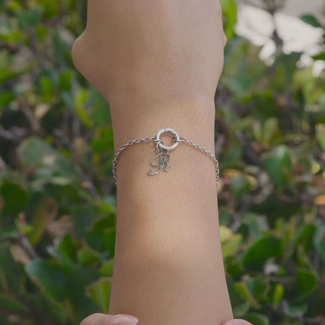 Silver Stainless Steel Charm Bracelet with Silver Initial Charm in "R" worn by model who is outside