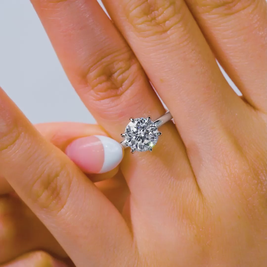 Video of a silver 2 carat 6 prong solitaire engagement ring on model with french tip nails