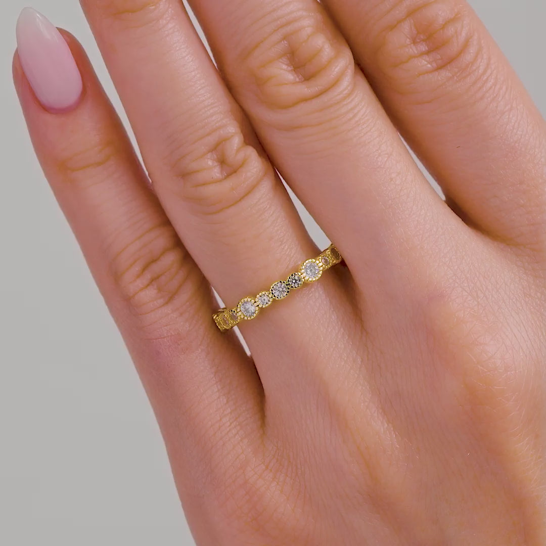 video of gold multi-size round cut stone eternity band on model