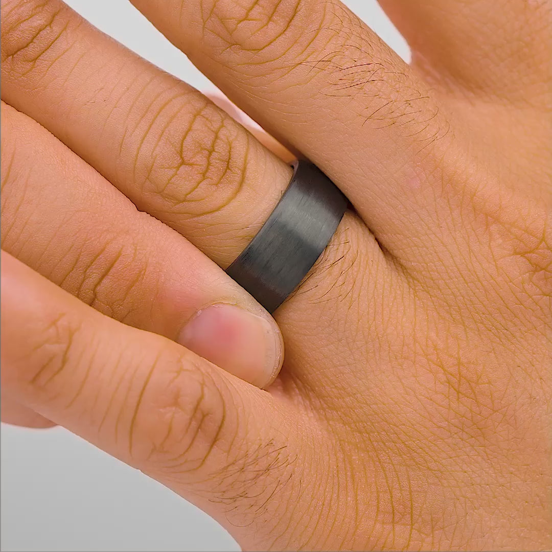 mens stealth affordable wedding ring on hand in studio setting