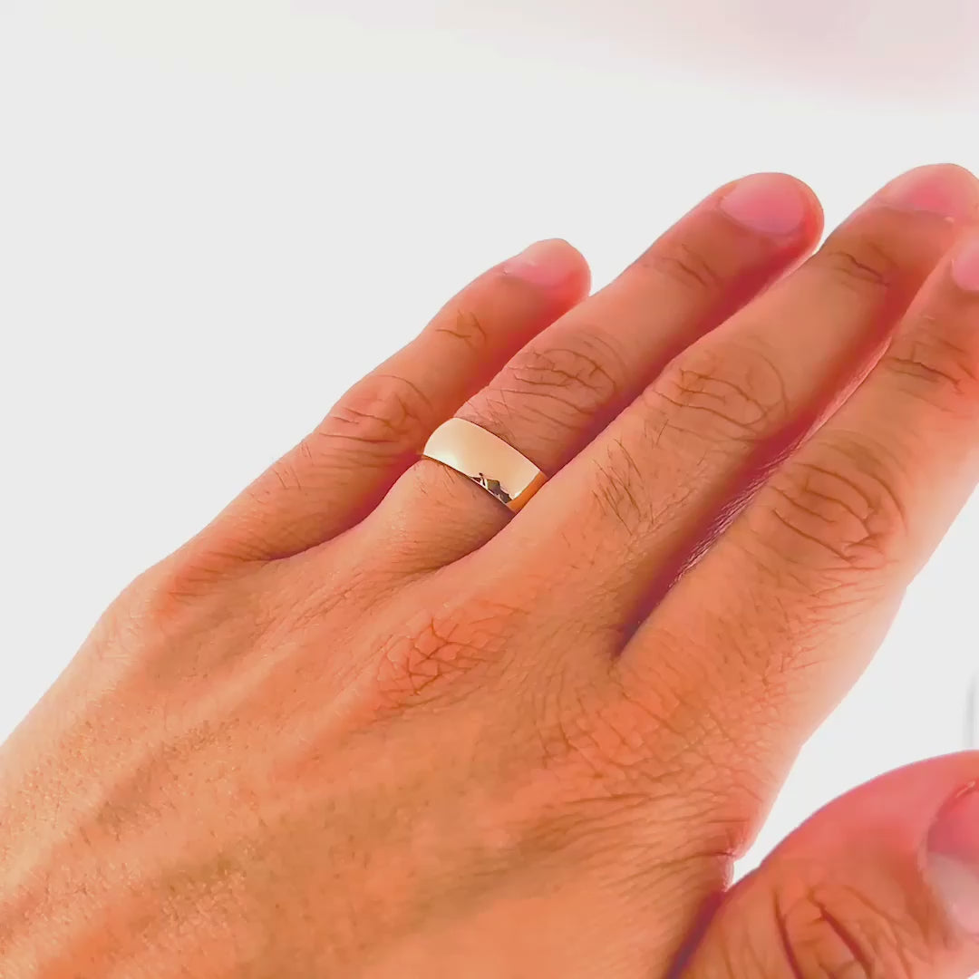 video of a rose gold affordable unisex horizon wedding band on model's hand 