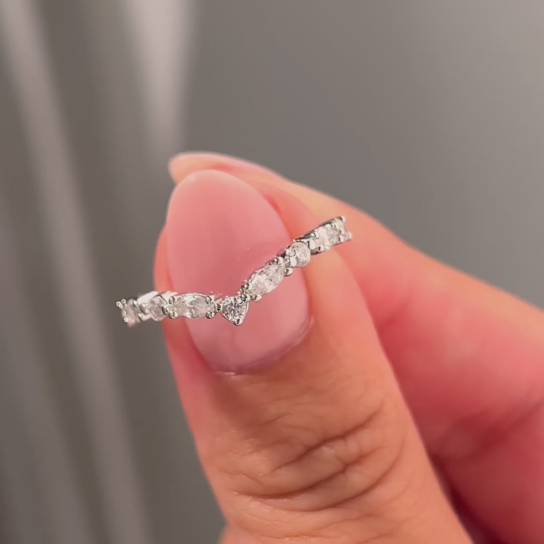video of silver vintage chevron half eternity wedding band held by model with light pink nails