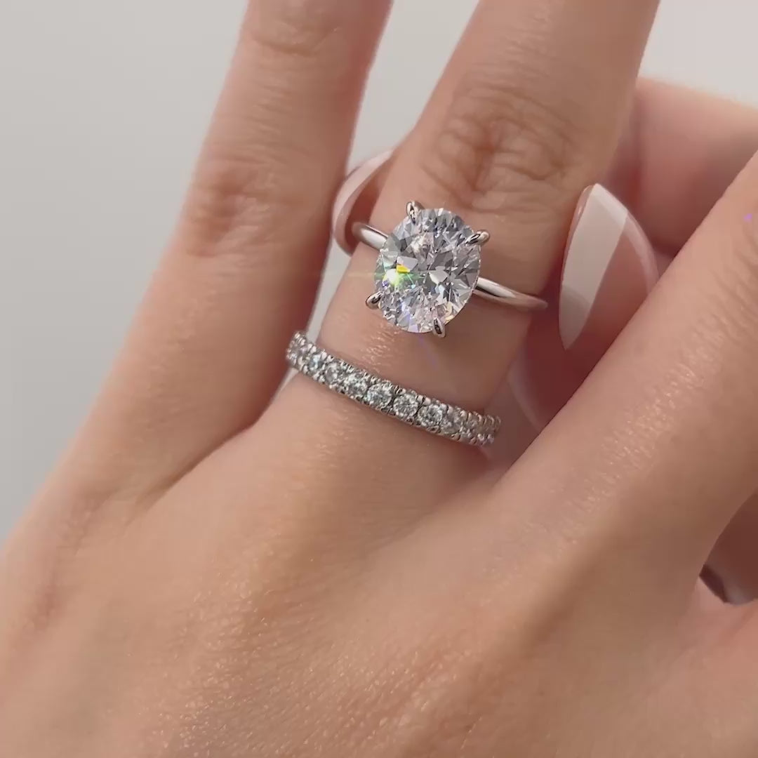 video of classic silver 3 carat oval cut wedding ring set on model with french tip nails