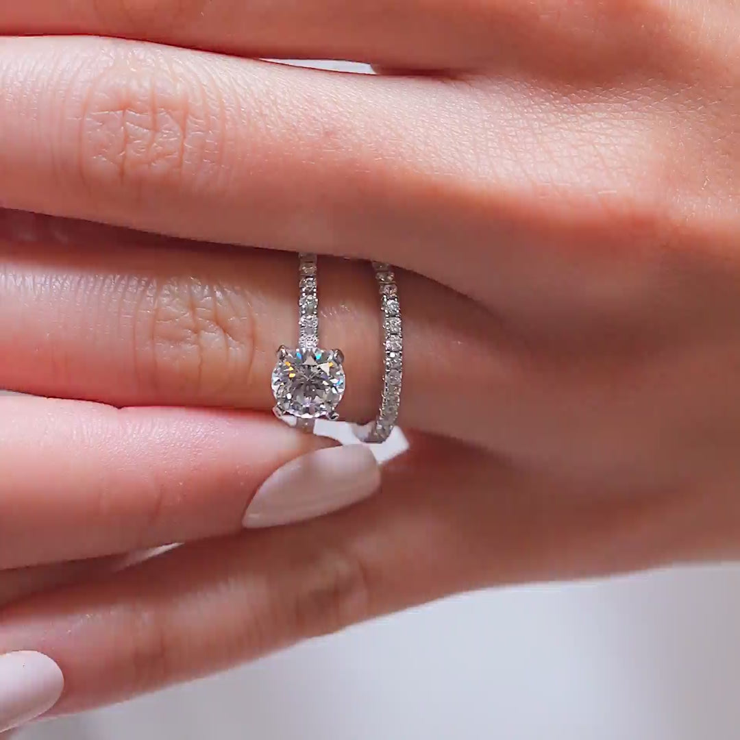 video of a simple & classic silver round cut half eternity wedding ring set on a model with white nails