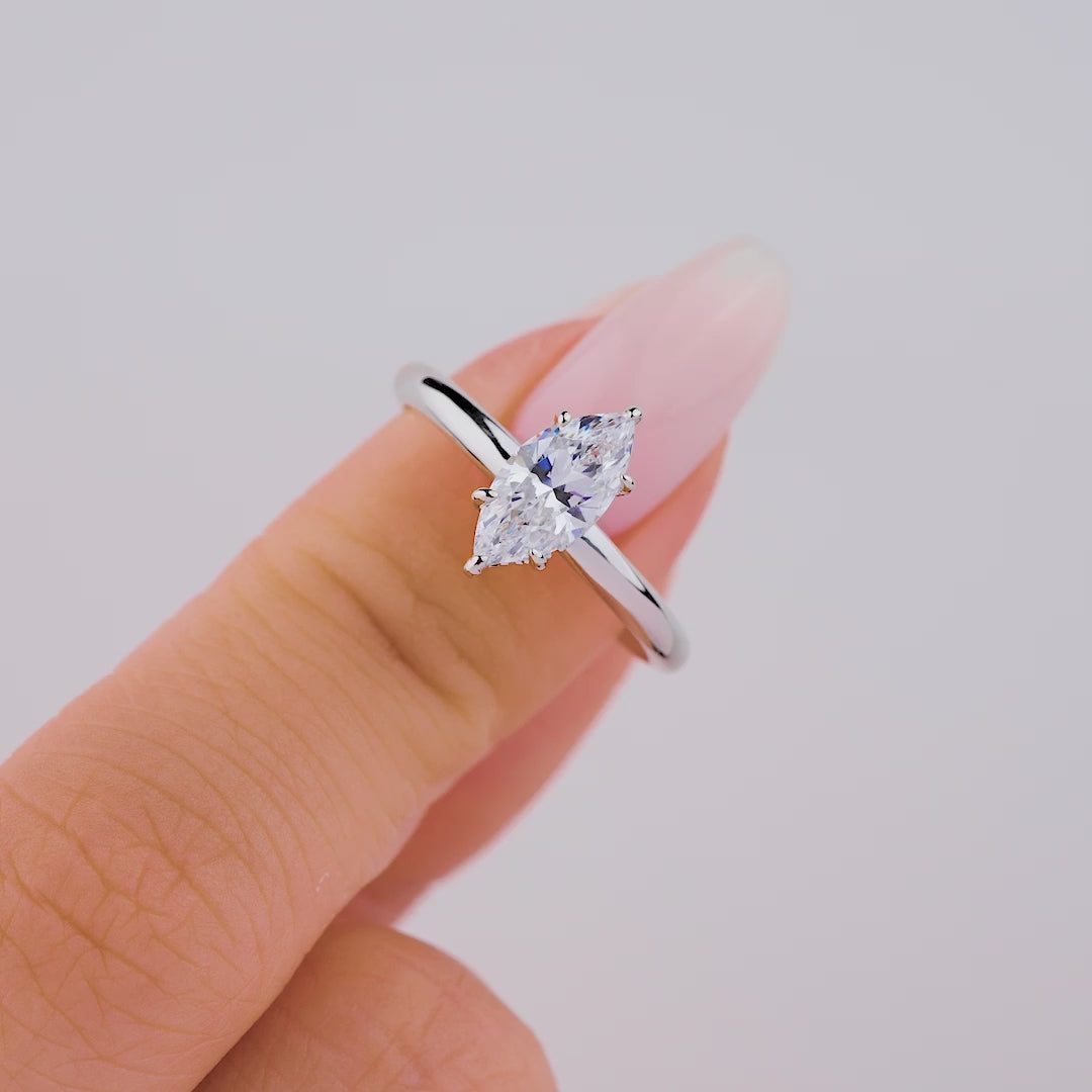 Video of petite silver marquise cut solitaire ring on model with light pink nails