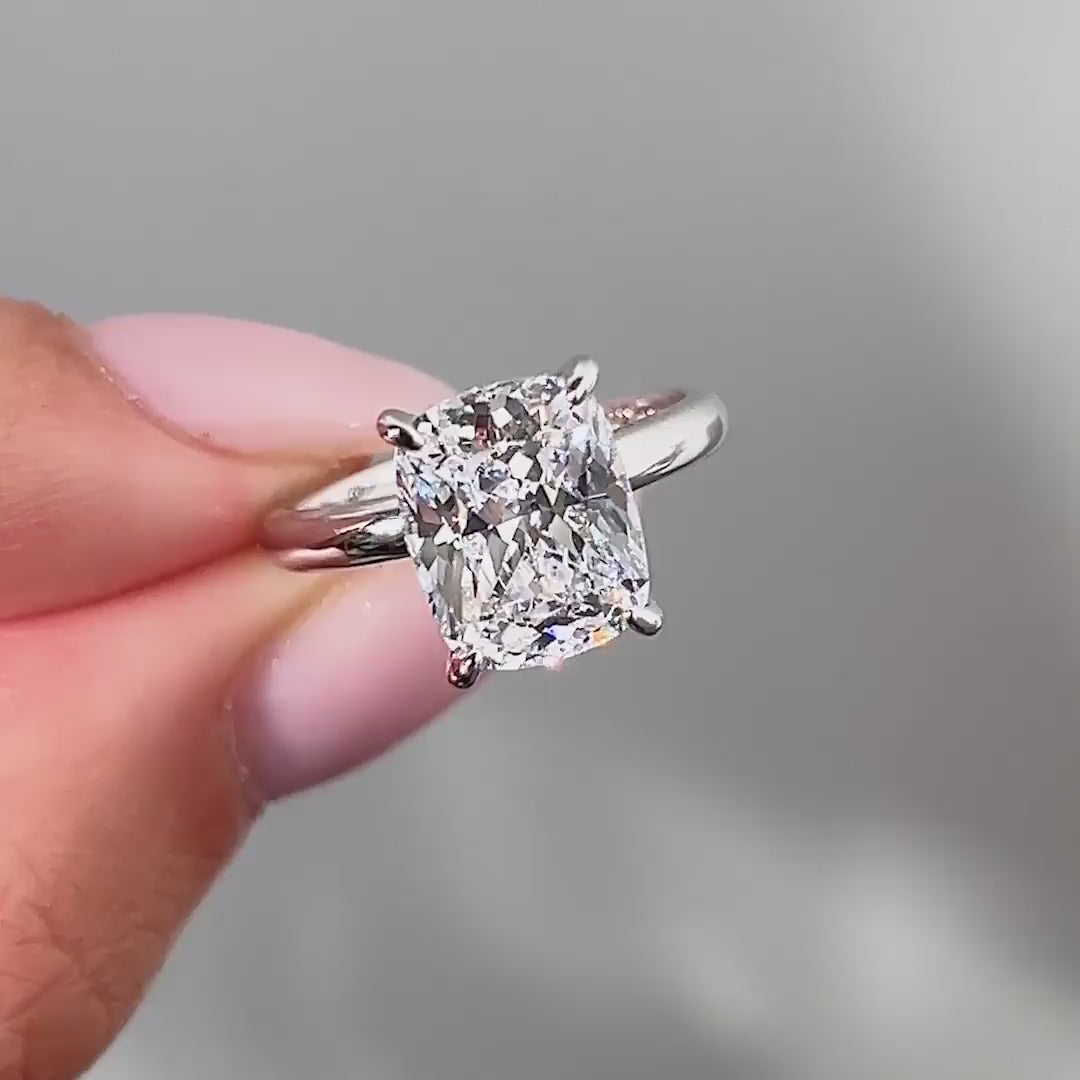video of silver 4 carat elongated cushion cut solitaire with a hidden halo on model