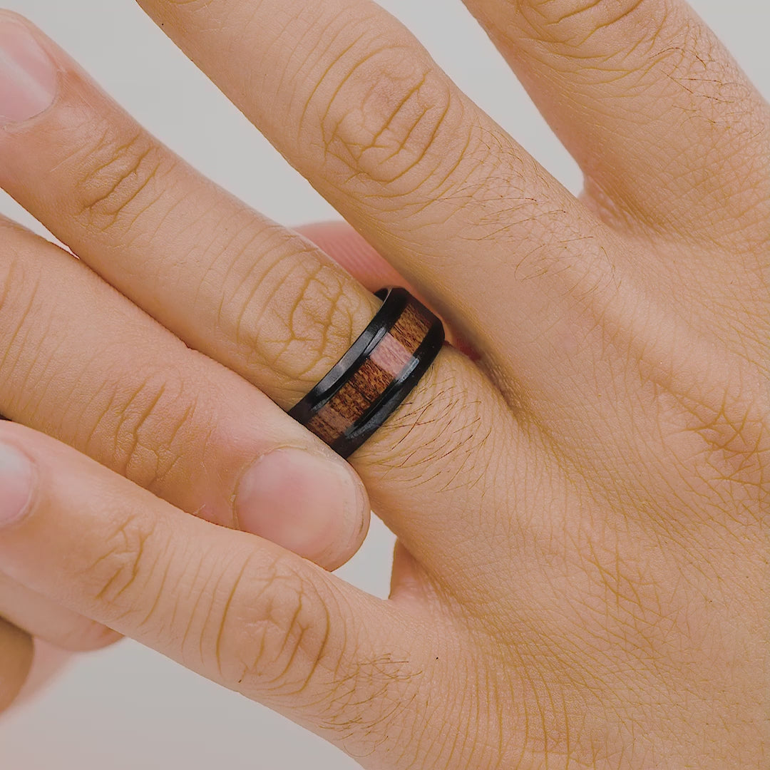 man wearing black wedding band with wood stripe in center