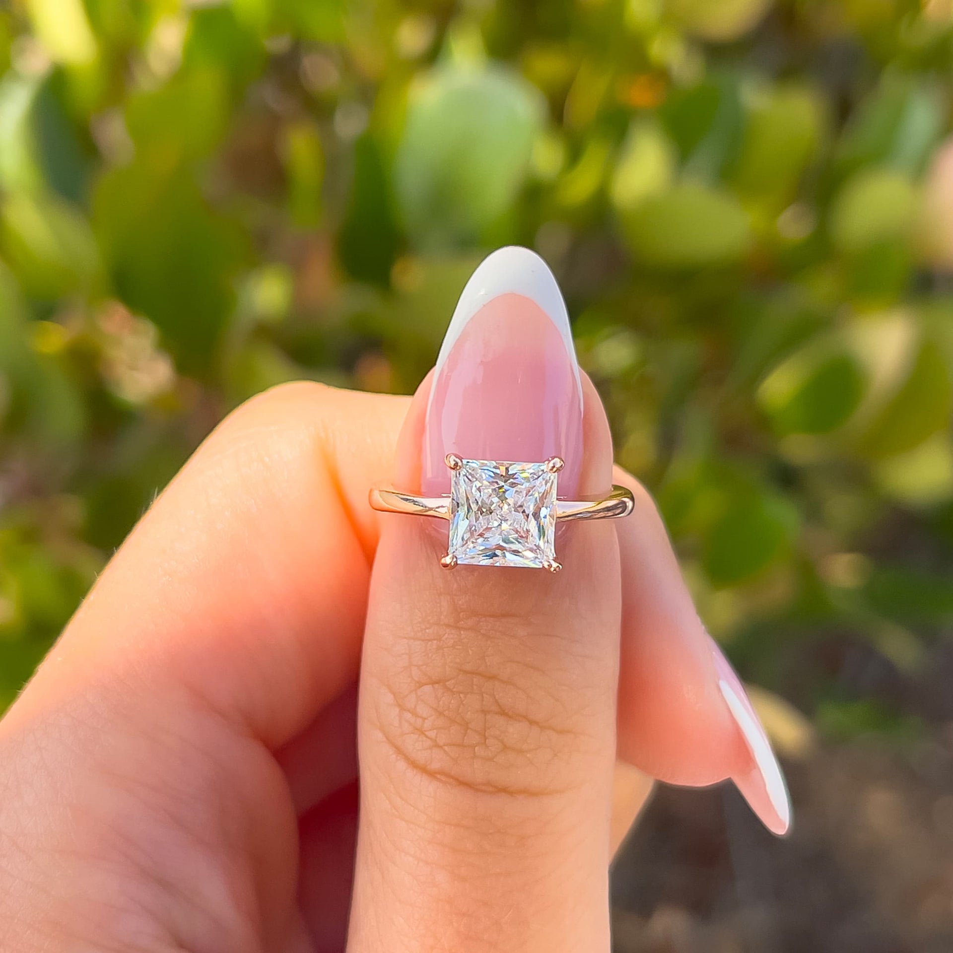 rose gold 2 carat princess cut solitaire engagement ring on hand with french tip nails