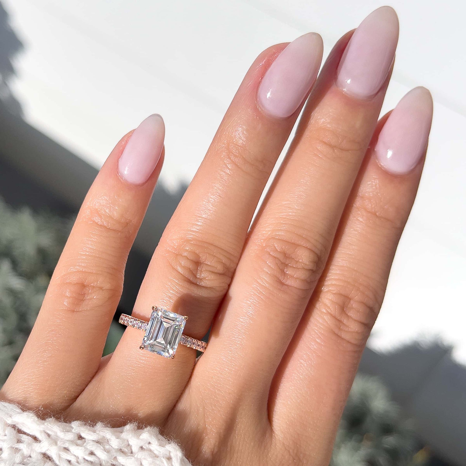 stunning emerald cut rose gold ring on model's finger