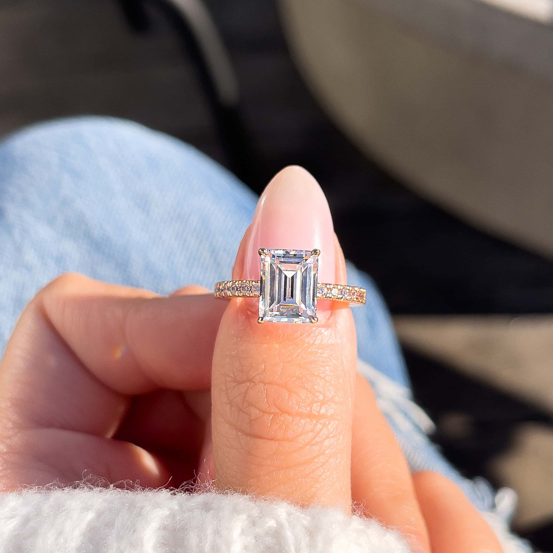 stunning emerald cut rose gold ring on model's finger