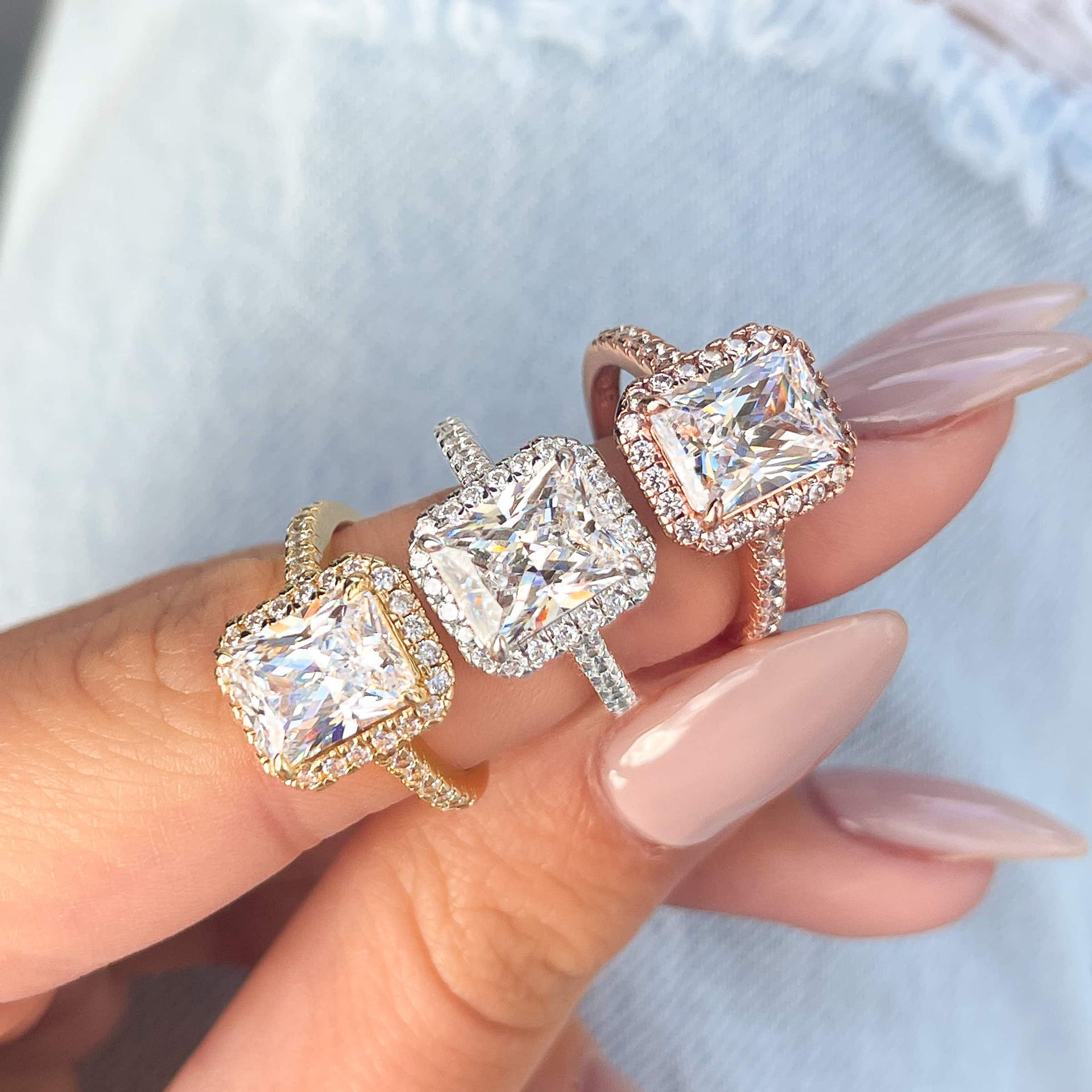 3.5 carat radiant cut halo engagement ring with half eternity band modeled in rose gold, silver, and gold