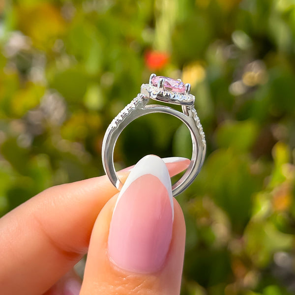 side view of silver round cut engagement ring with pink sapphire center stone