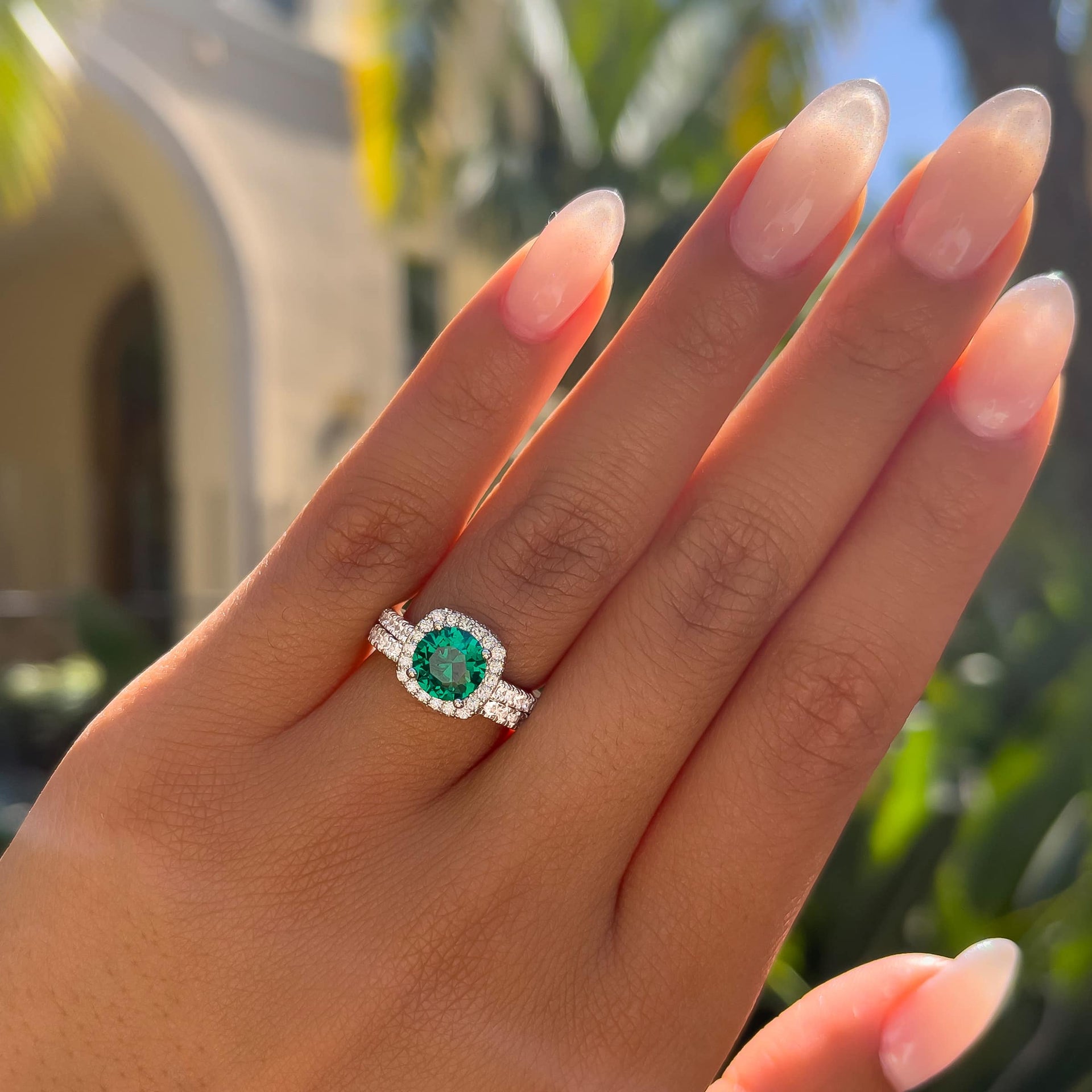 stunning silver simulated emerald stone half eternity wedding ring set on model with neutral nails