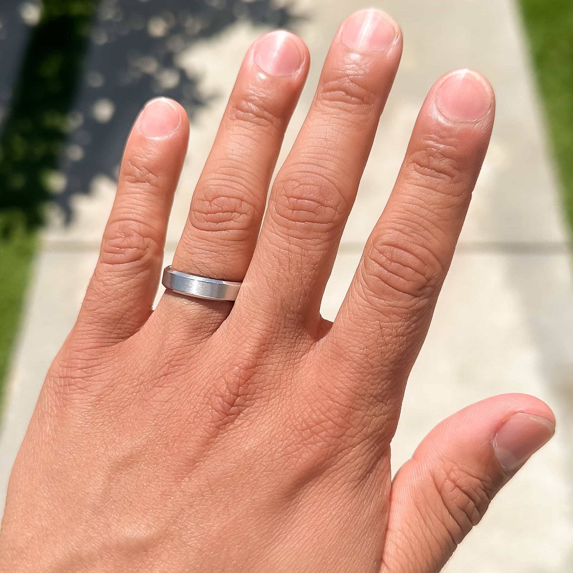 silver infinity wedding band on man's hand