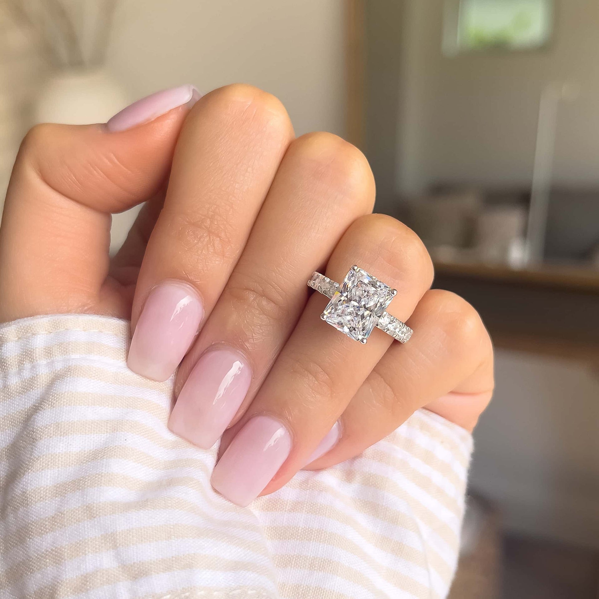 3.75 carat silver engagement ring shown in silver modeled on female with light pink nails and a striped top