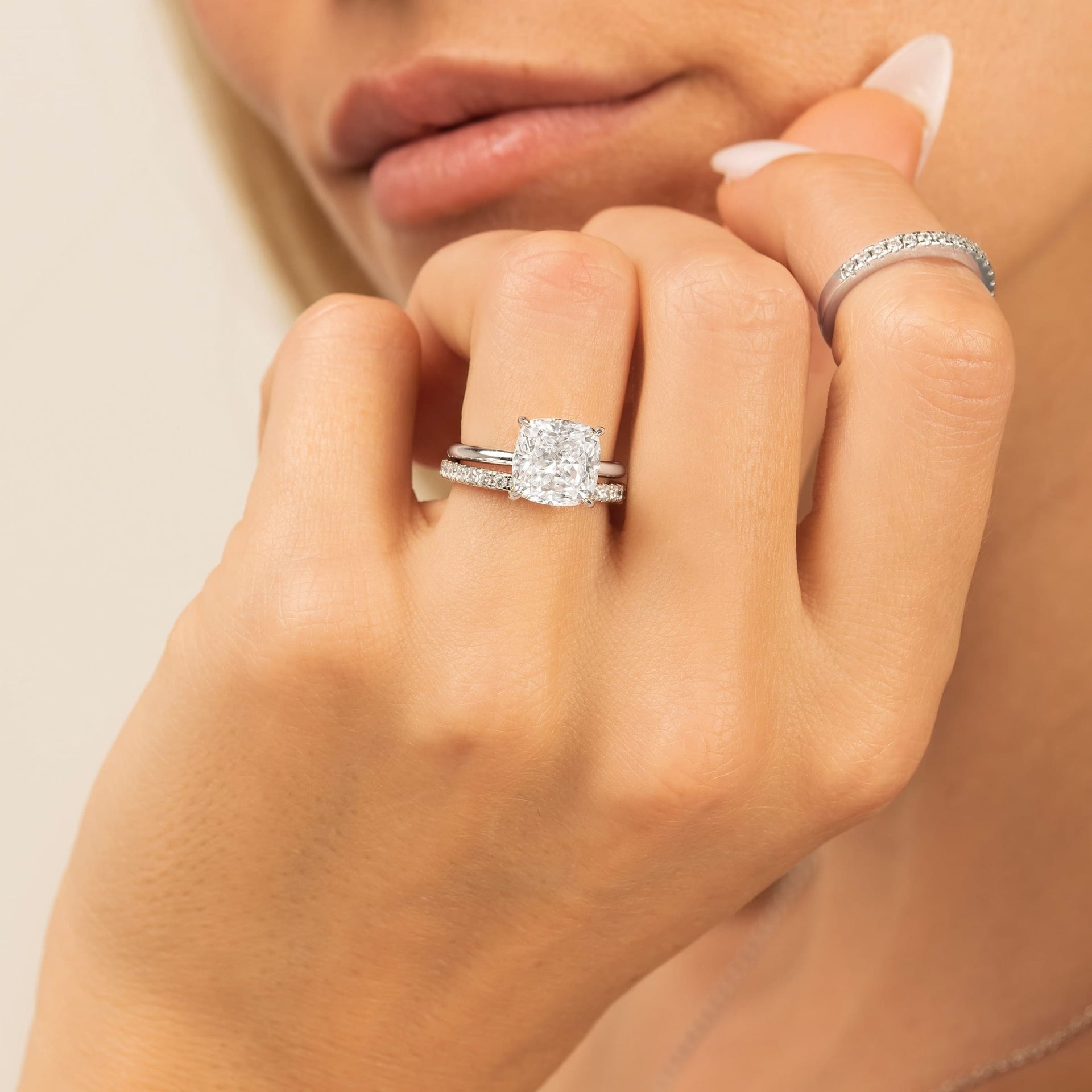 woman wearing silver engagement ring with promise wedding band