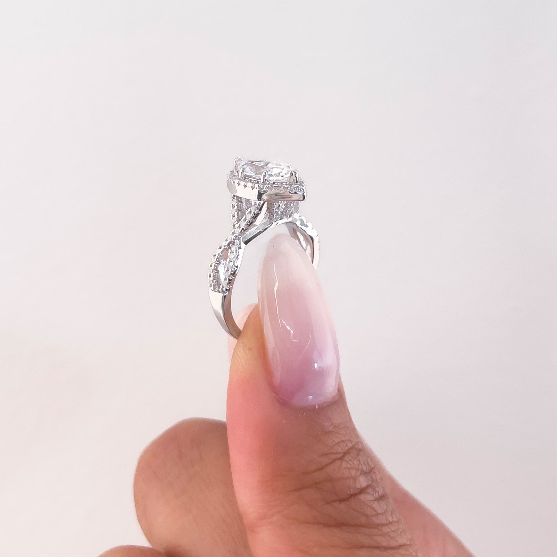 setting shot of stunning vintage silver marquise cut engagement ring in hand with neutral nails