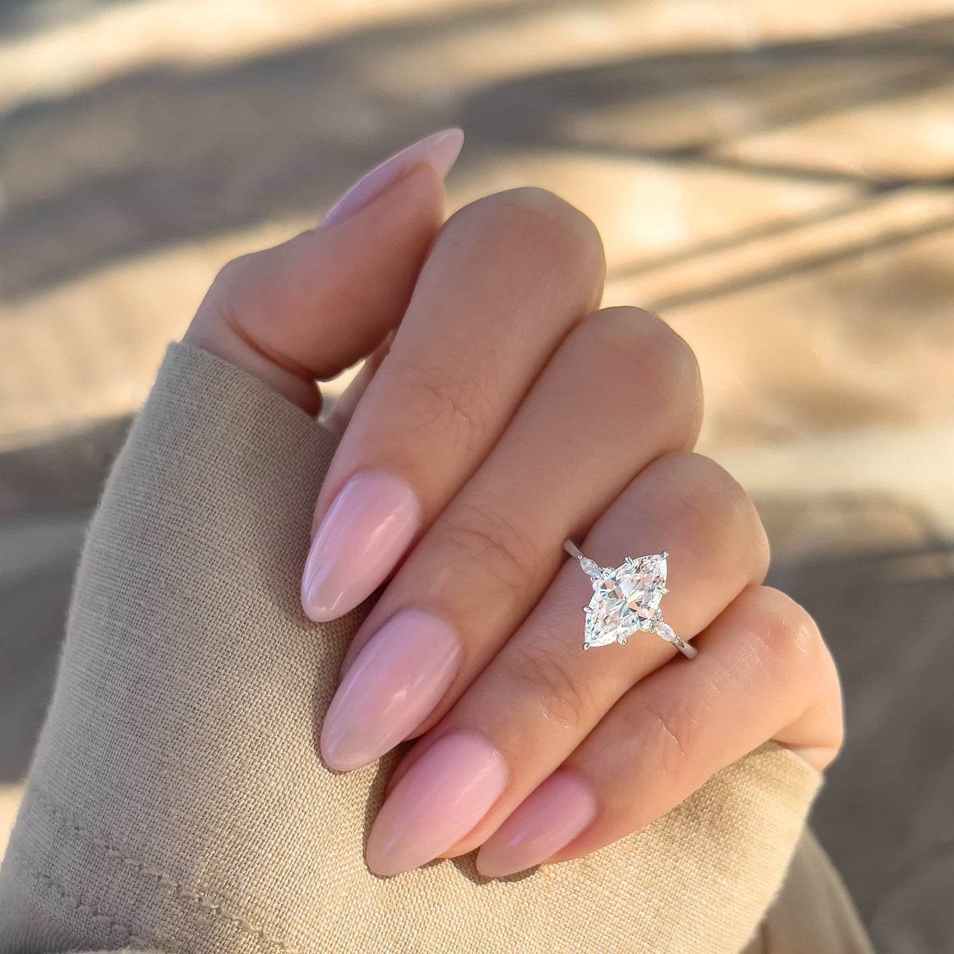 vintage marquise cut silver engagement ring on model with light pink nails