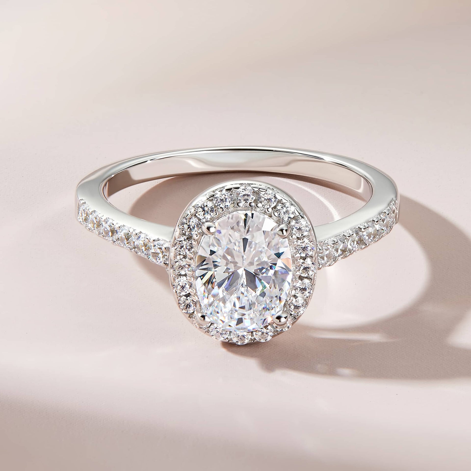 silver halo engagement ring on soft purple background