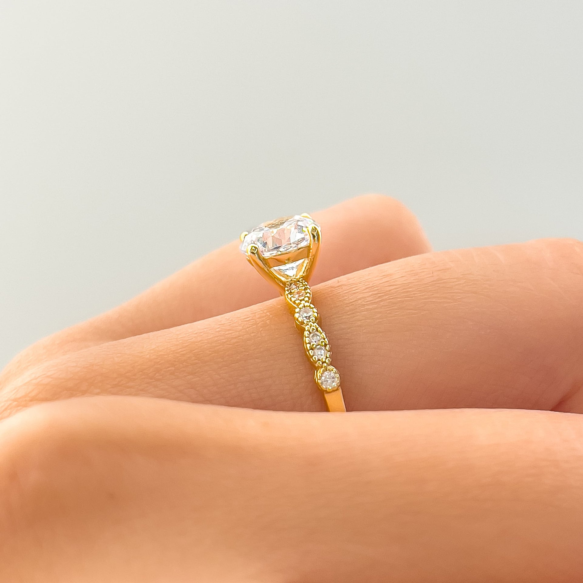 setting shot of gold engagement ring with vintage detailing on the band