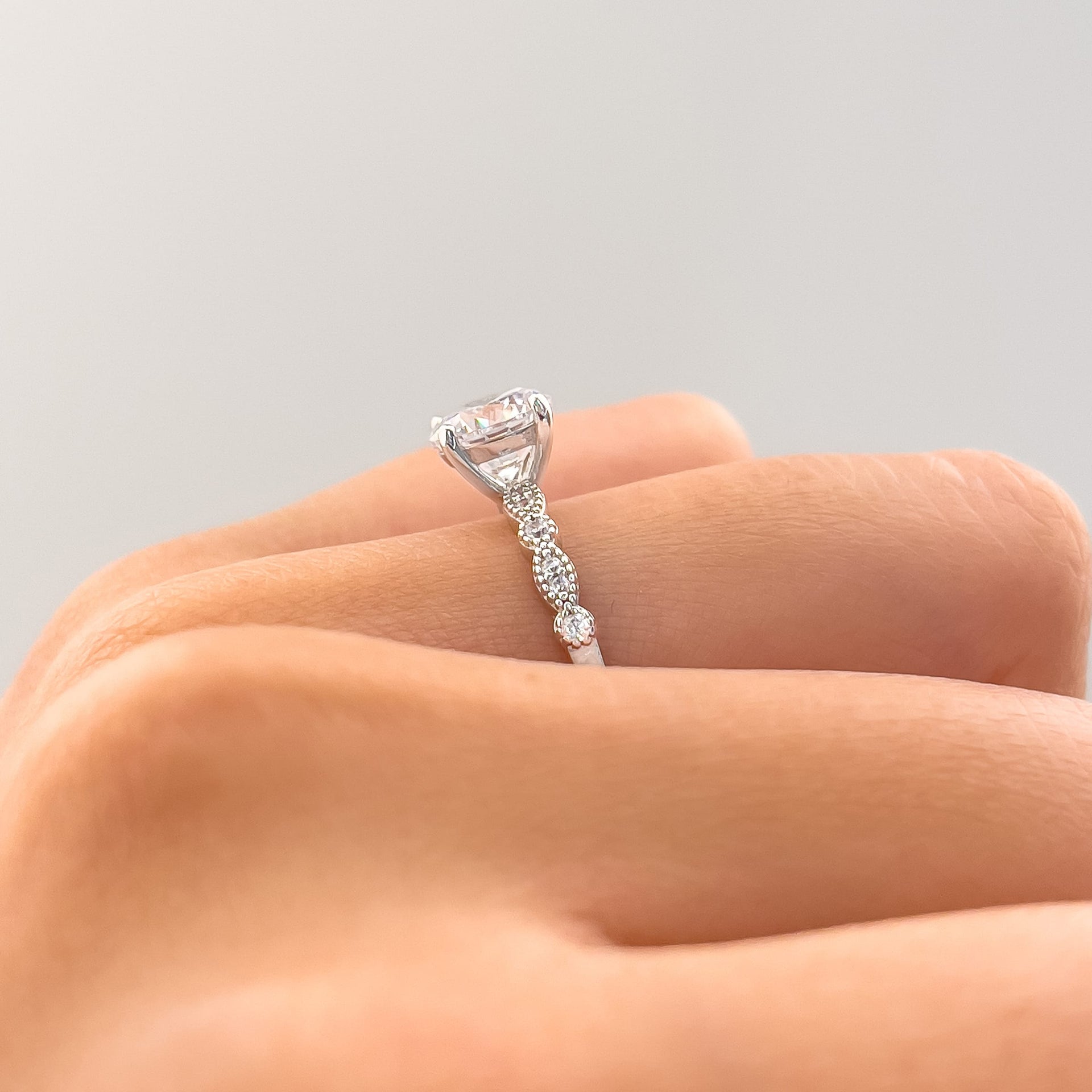 gorgeous silver setting shot with vintage detailing on ladies hand with white background