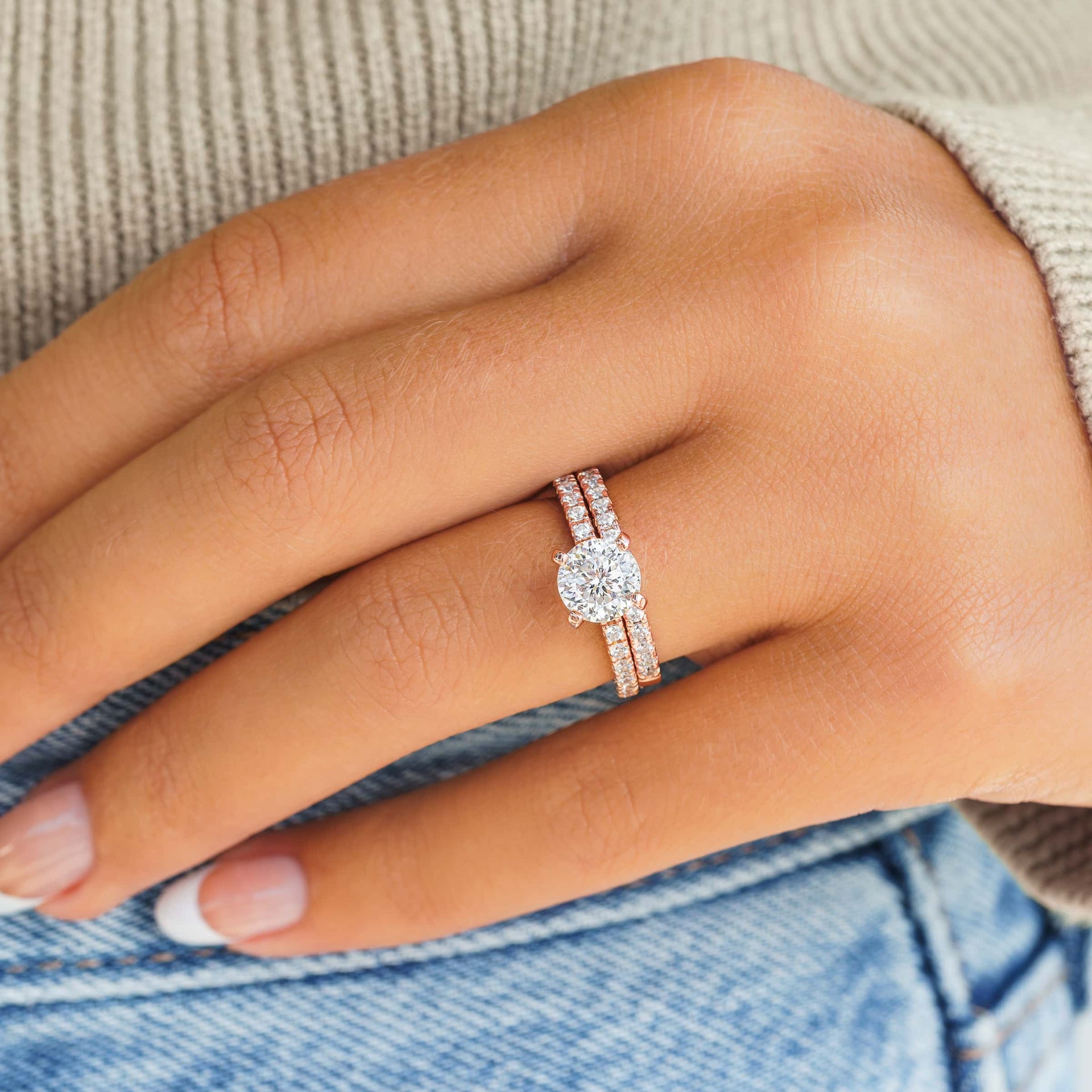 rose gold round cut wedding ring set on model with french tip nails