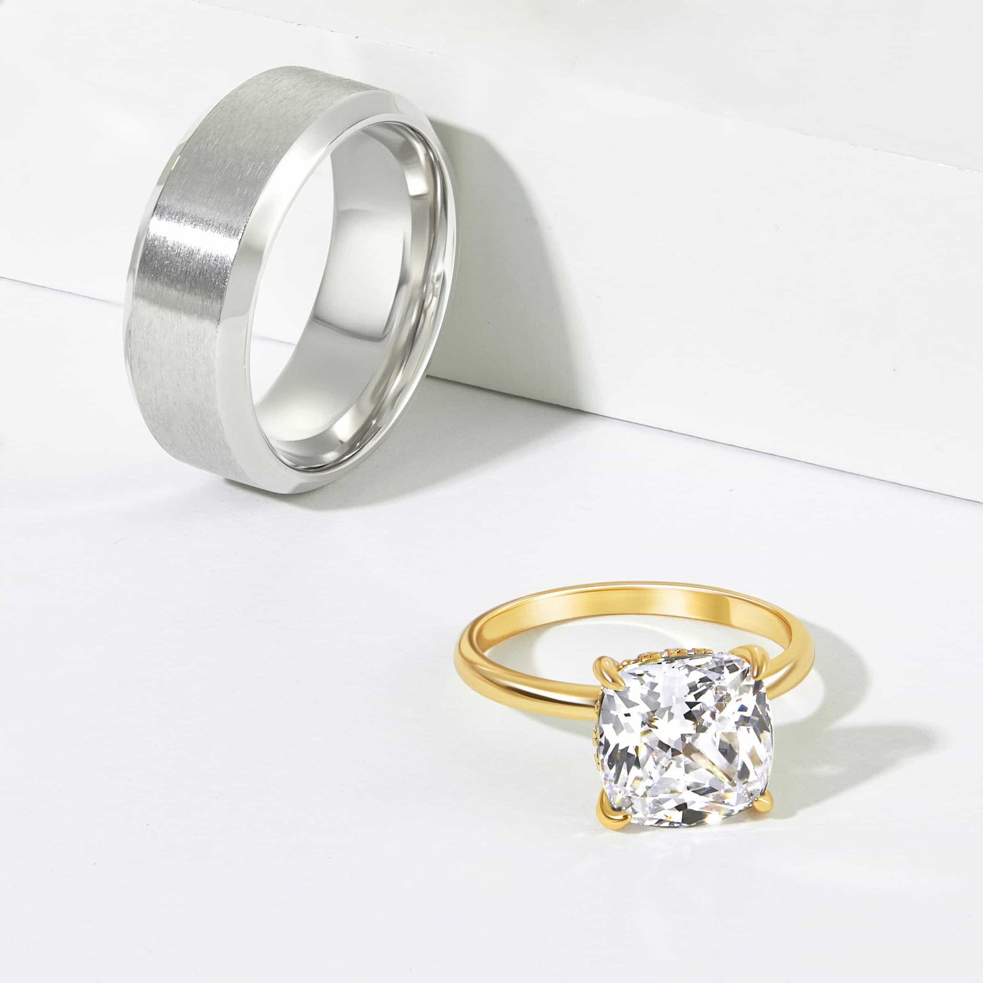 stunning gold cushion cut engagement ring shown with silver men's wedding band on white backdrop