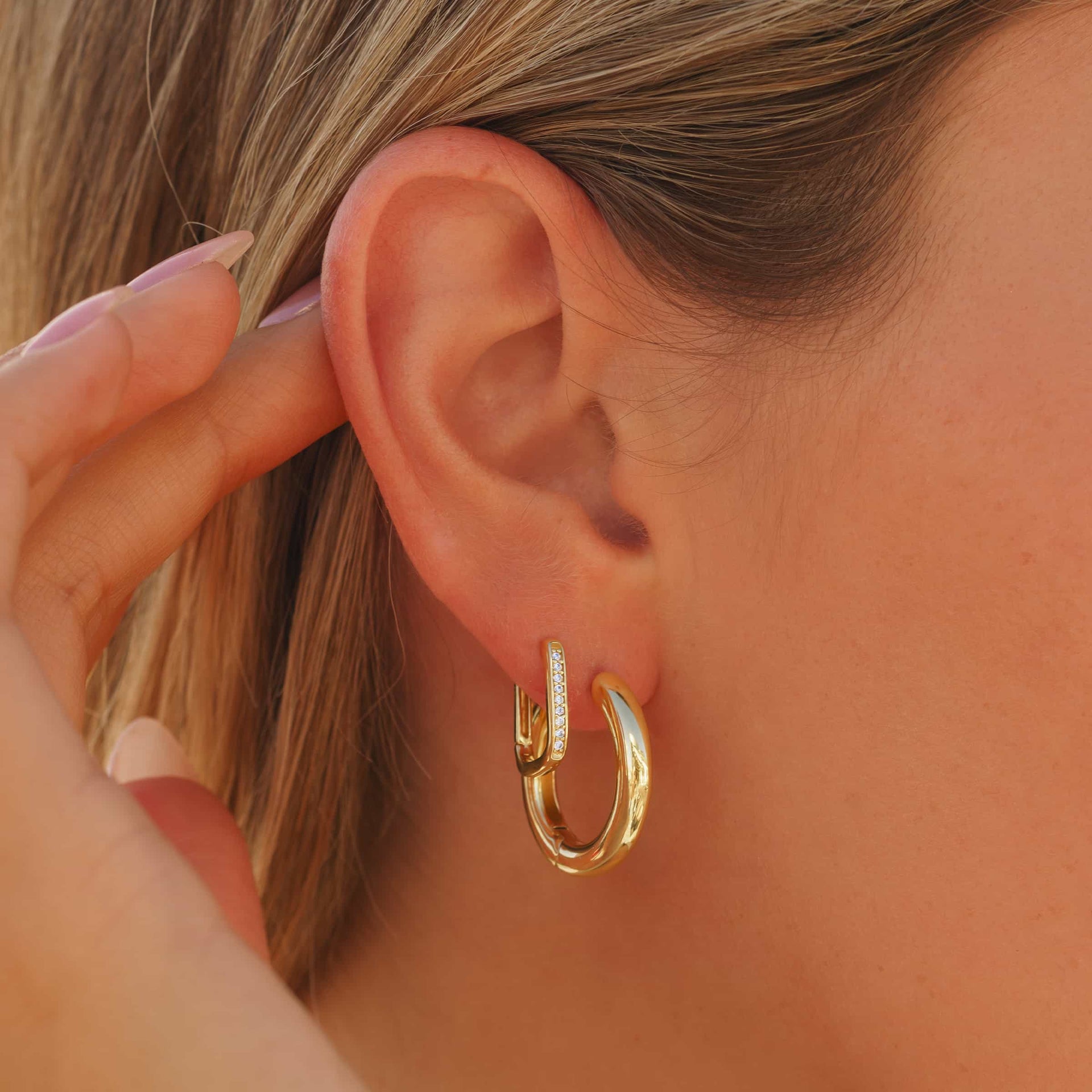 stunning gold hoop earrings in the violet and the cora shown on model's ear
