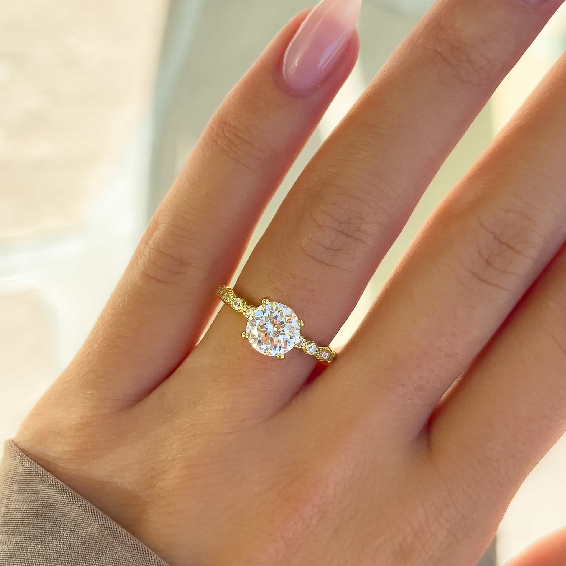 gold round vintage cut engagement ring worn on woman's hand with manicured nails