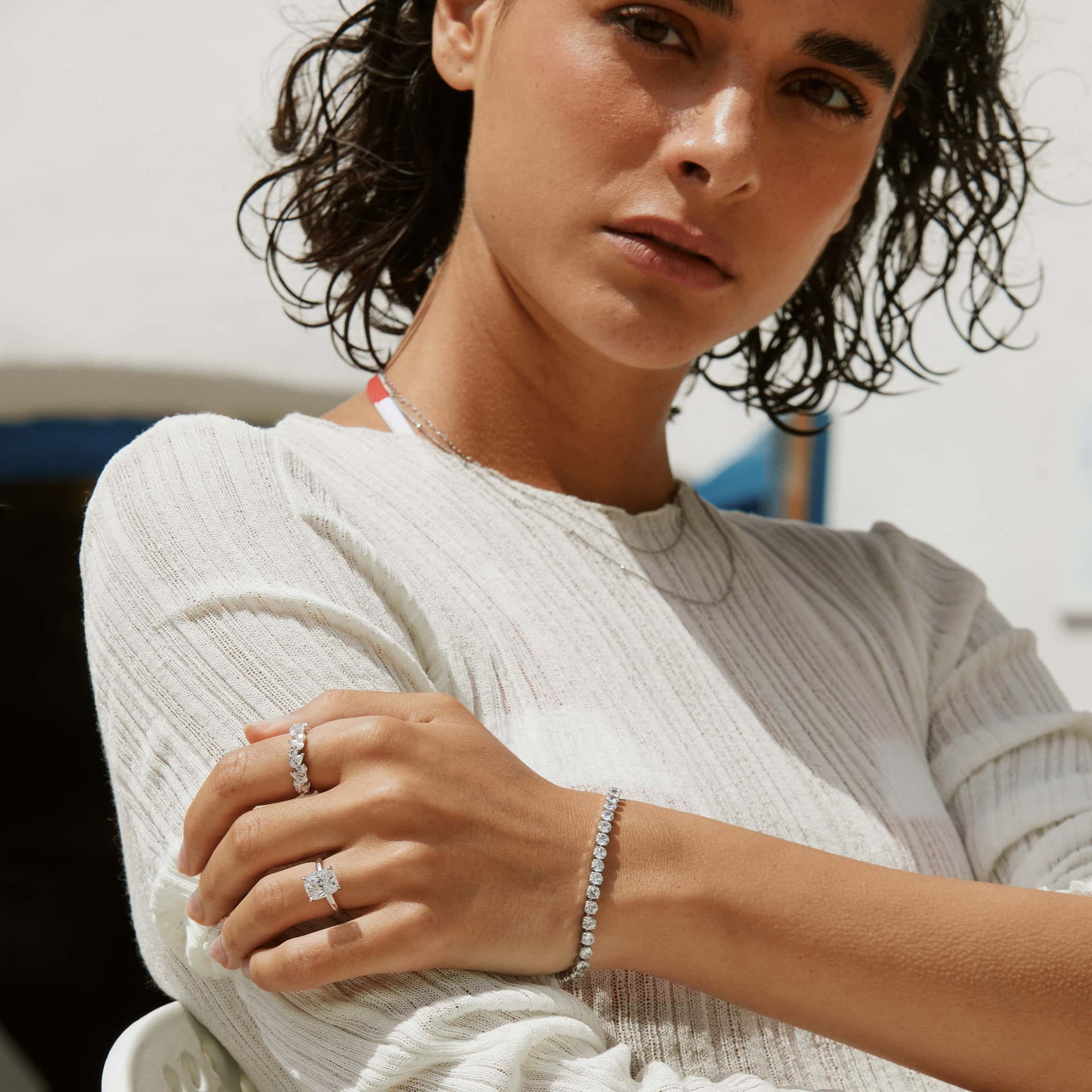 silver alexis engagement ring with alia band and silver venus tennis bracelet on brunette model with white dress