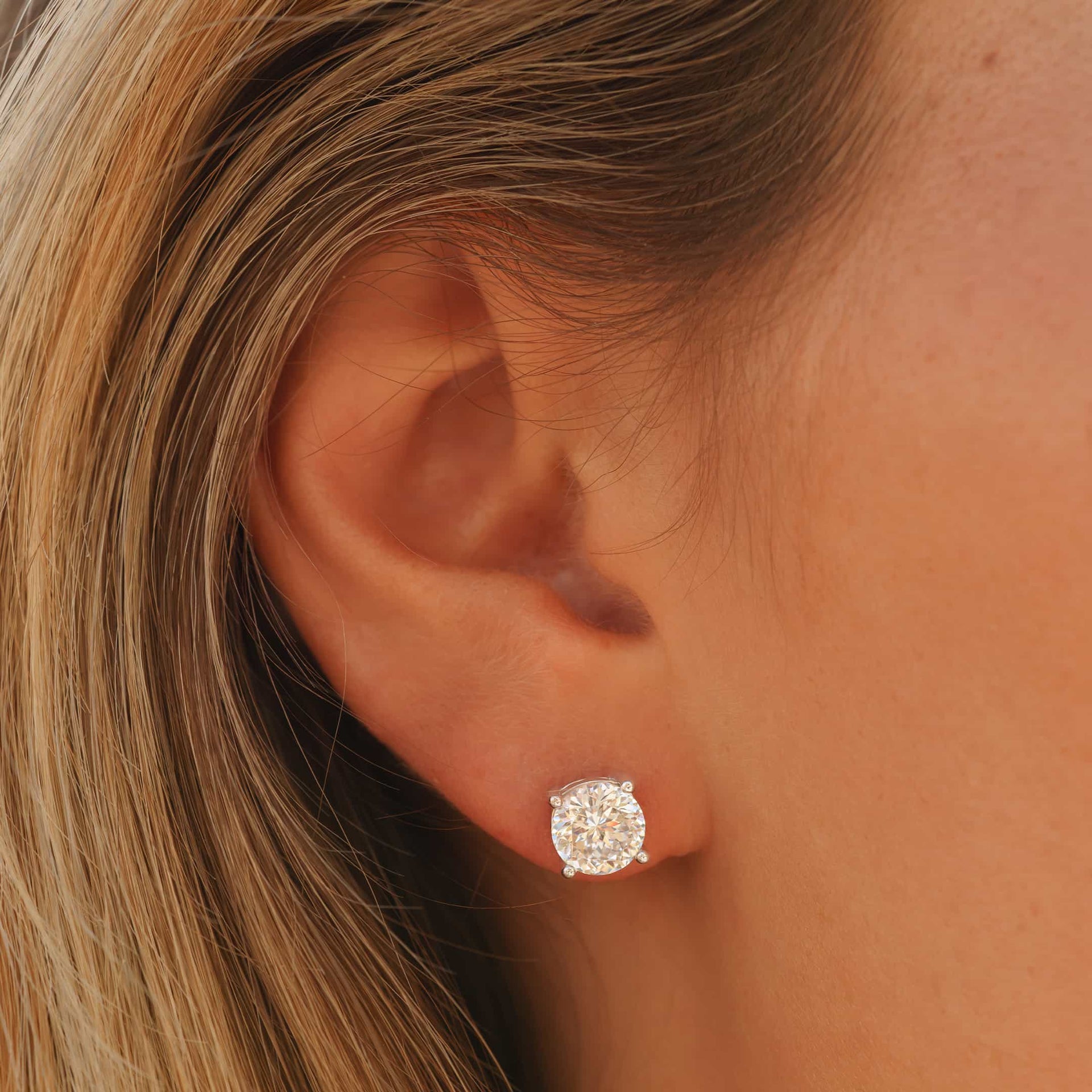 Beautiful simple round cut stud earring on model's ear