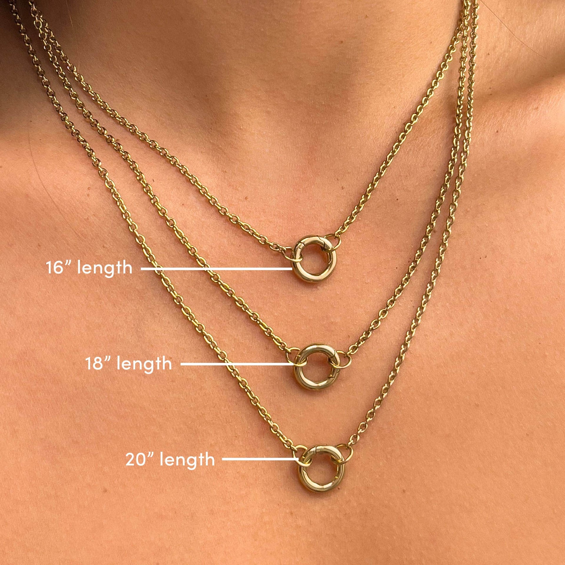 A gold charm necklace shown on a model in 3 lengths. From top to bottom: 16" length, 18" length, 20" length