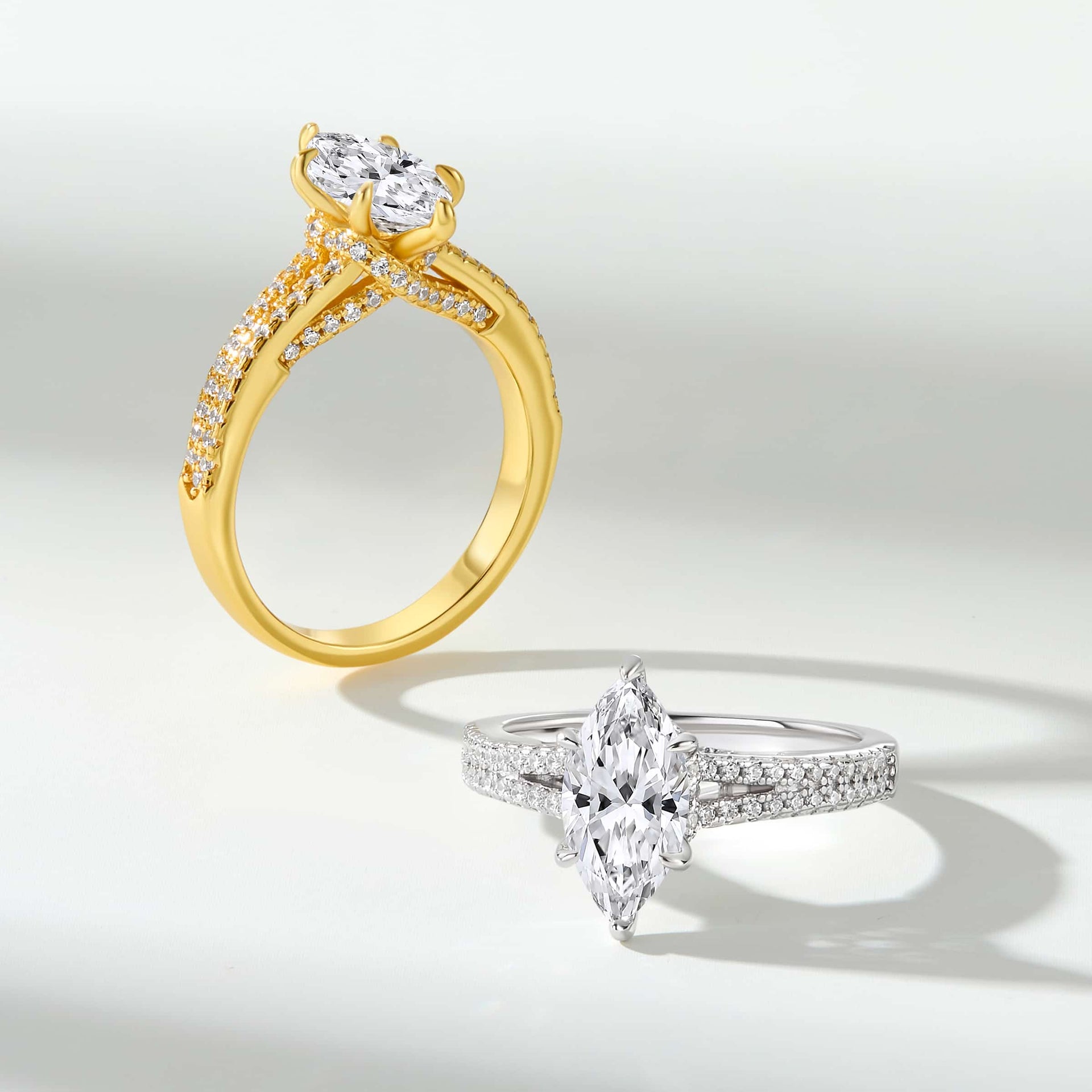 A vintage style 2 carat marquise cut engagement ring shown in gold and silver on an off white background