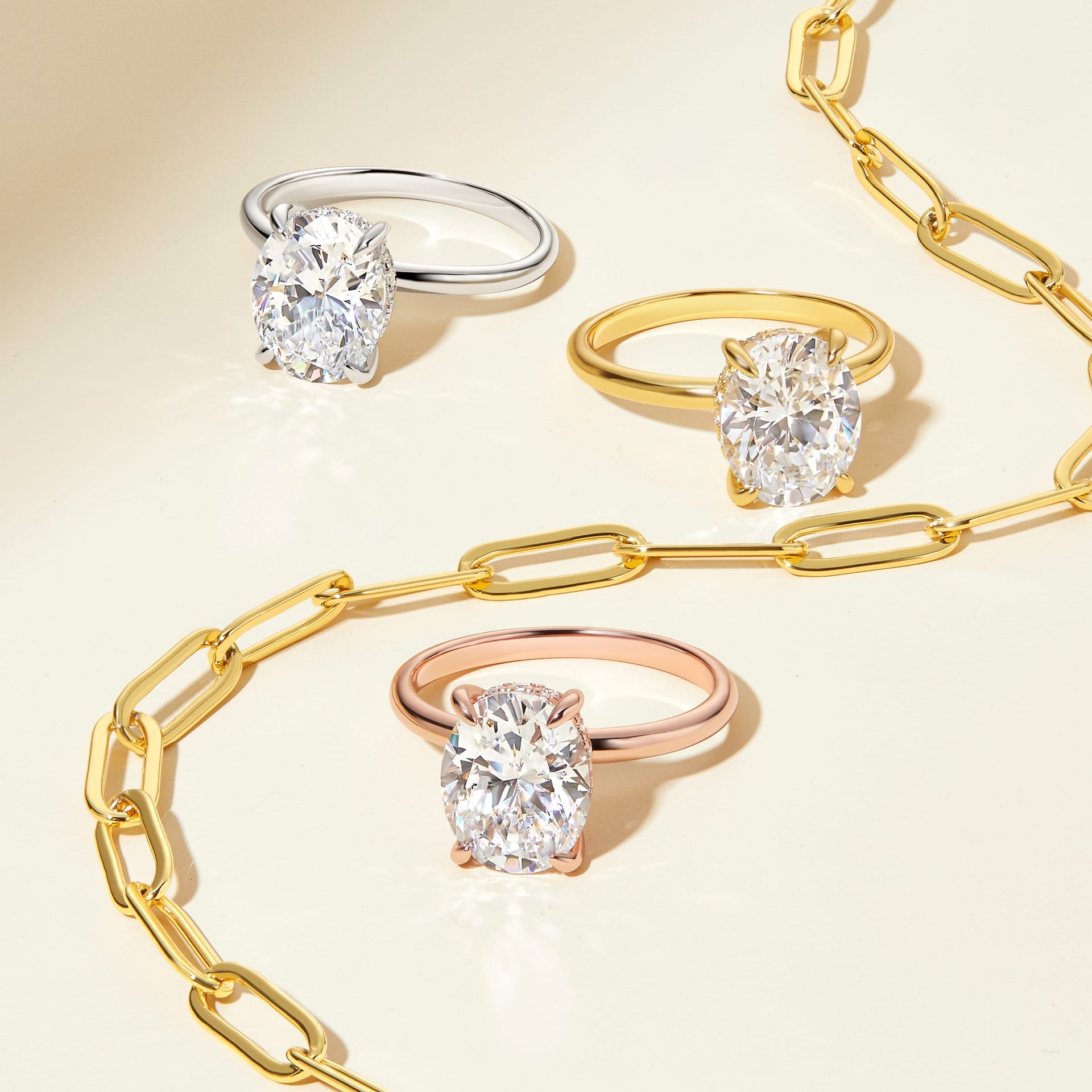 oval 3ct solitaire engagement rings shown in silver, gold, and rose gold with gold necklace