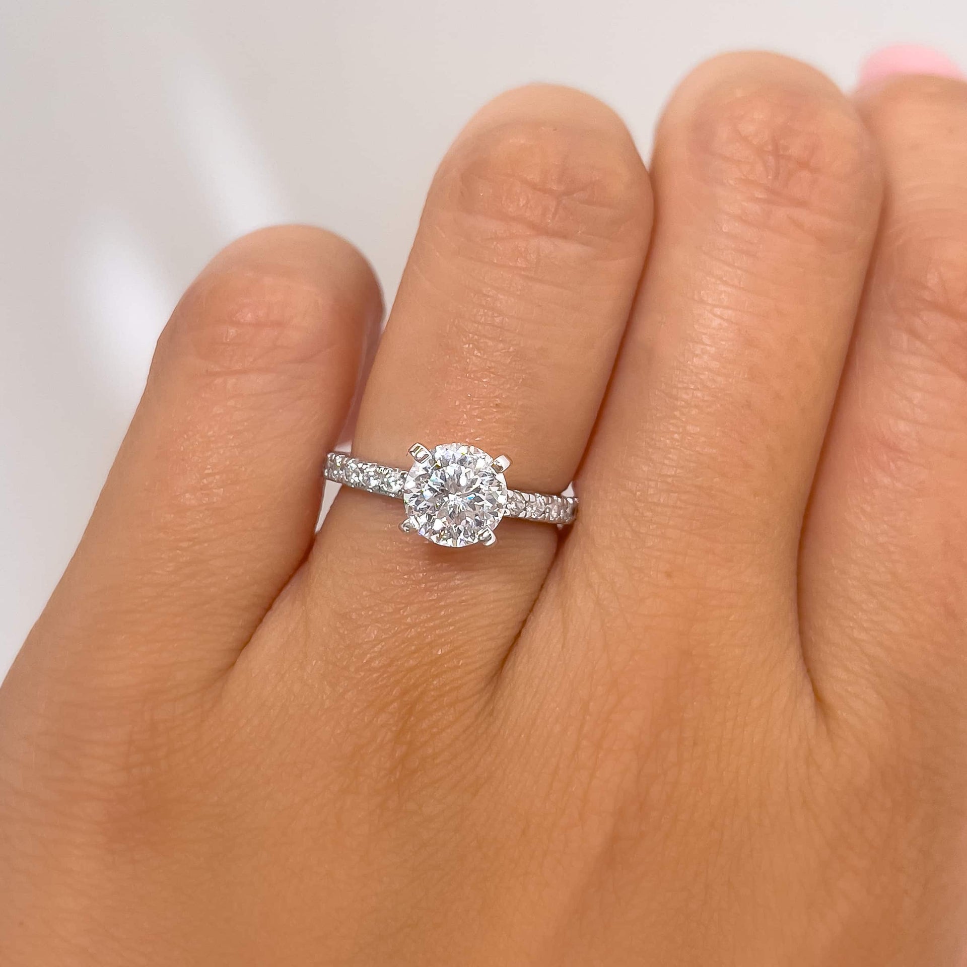 close up of silver 1.75 carat round cut engagement ring with half eternity detail